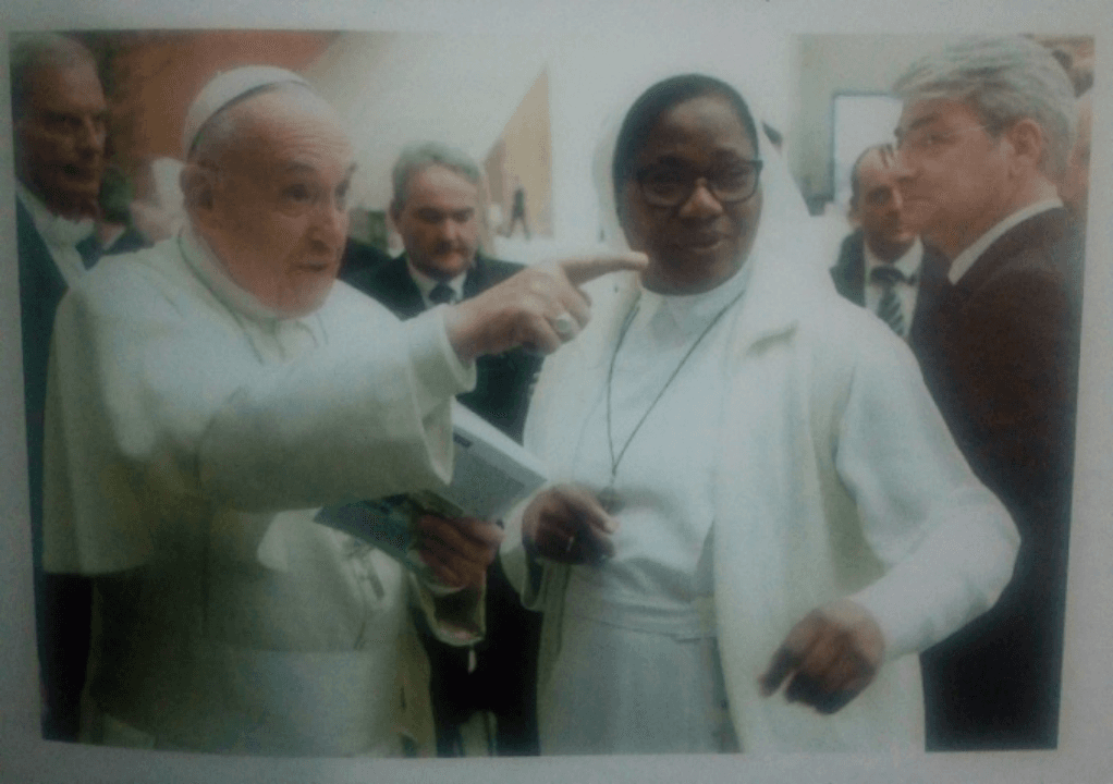 Pope Francis studying the biography and pointing out the author